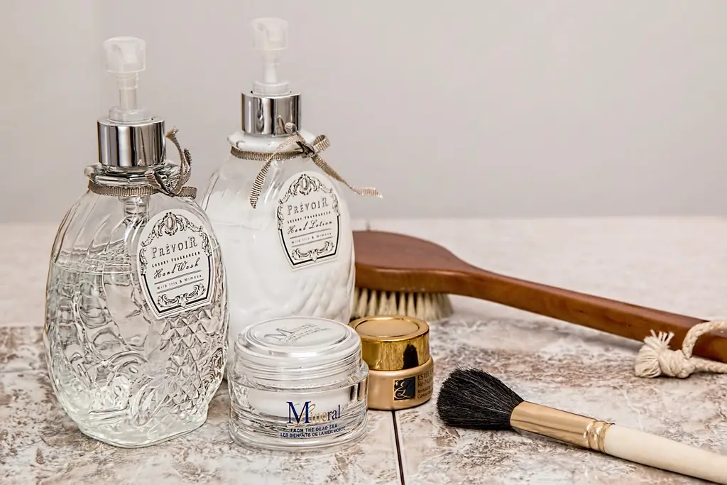 Frascos de vidro com cosméticos e pincéis de aplicação