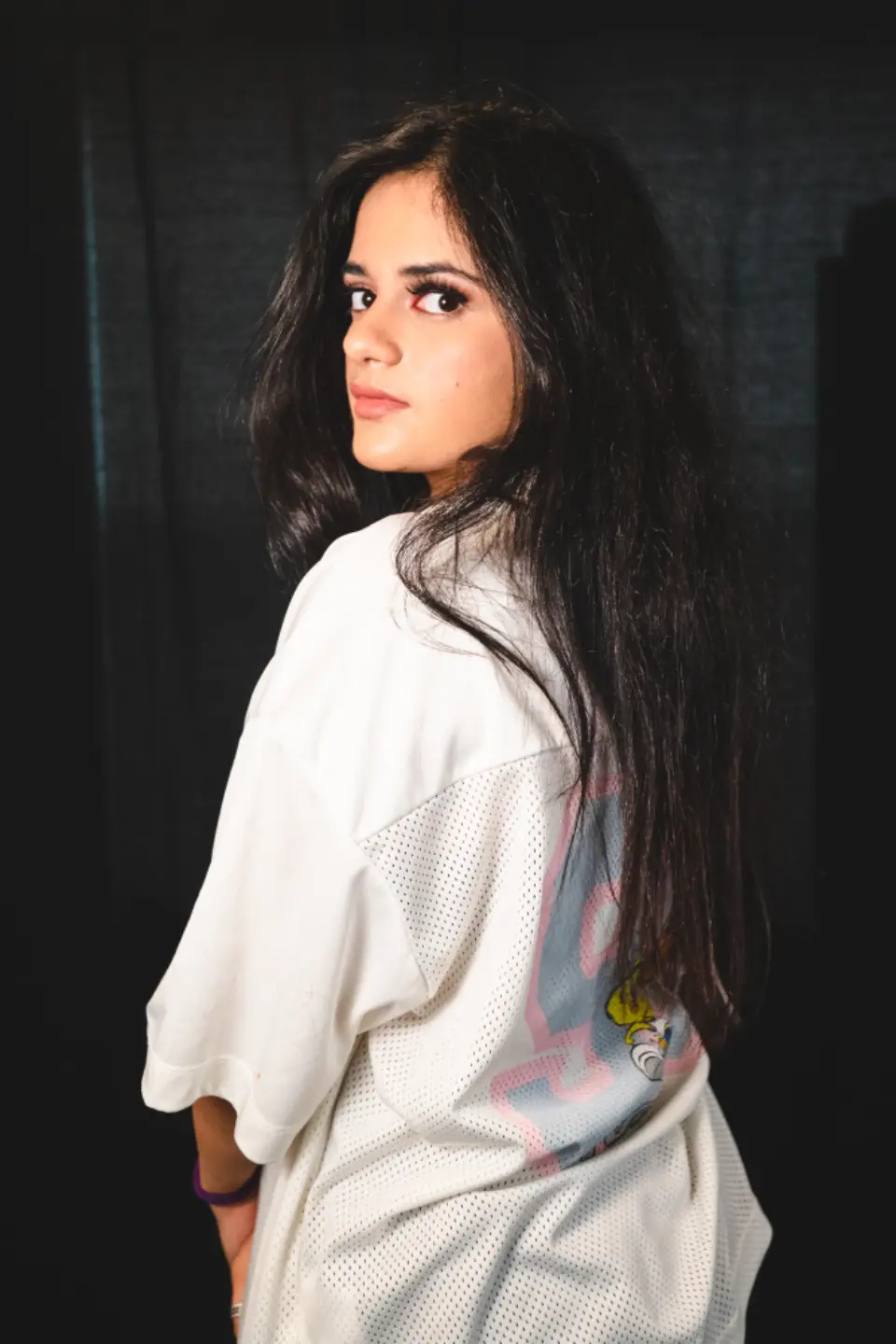 Mulher com camisa branca sobre fundo escuro