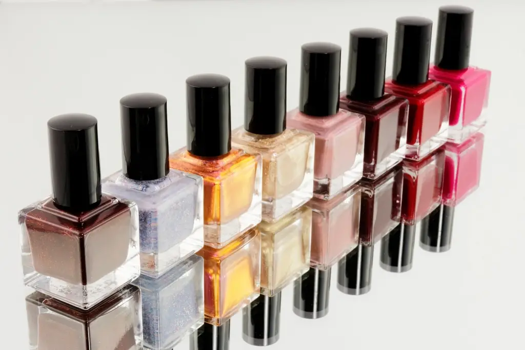Fileira de vidros de esmalte em tons de vinho, lilás, dourado, nude, vermelho e pink